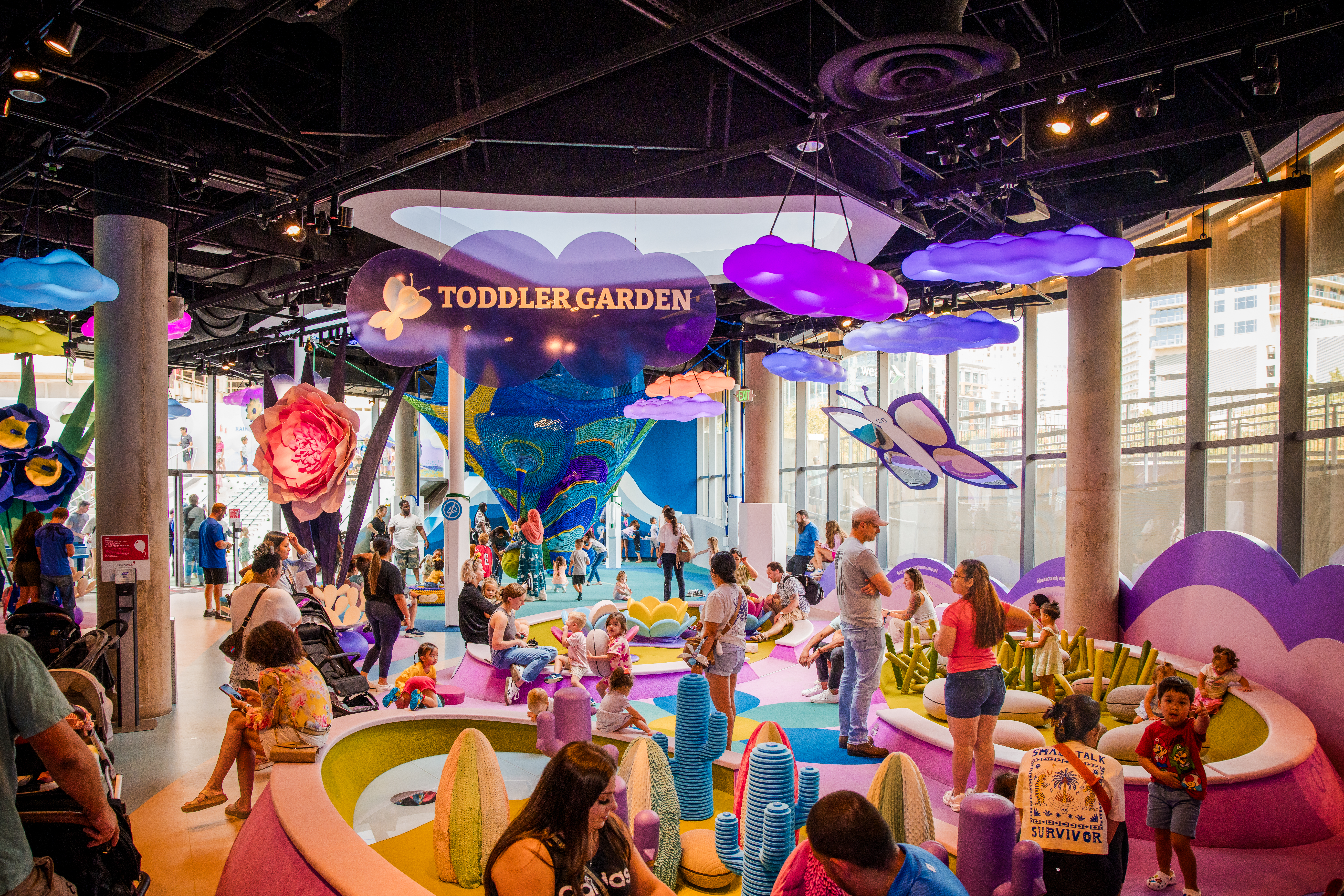 Wide shot of the Moody Family Children's Museum filled with children and parents
