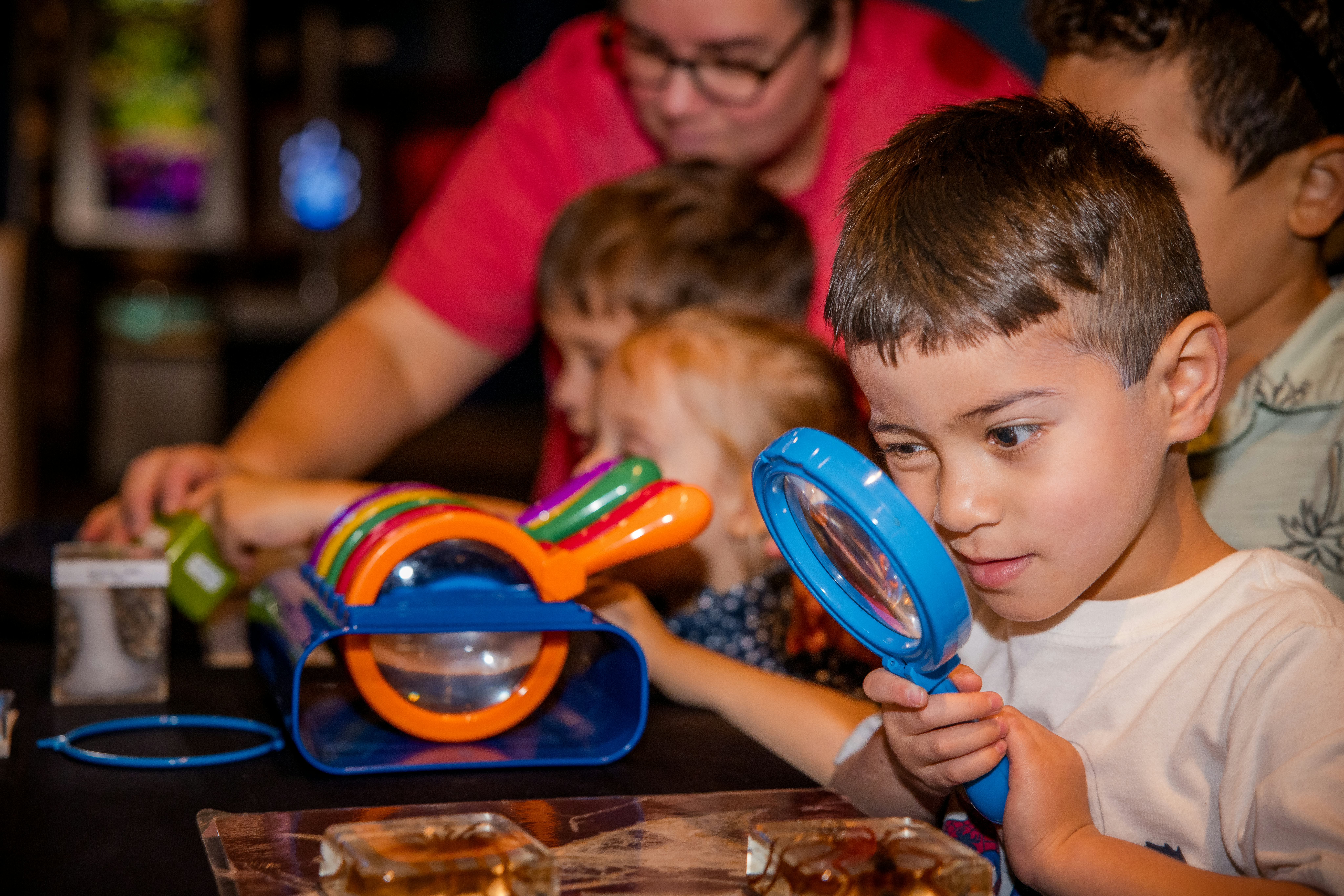 Young boy looking through magnifying glass