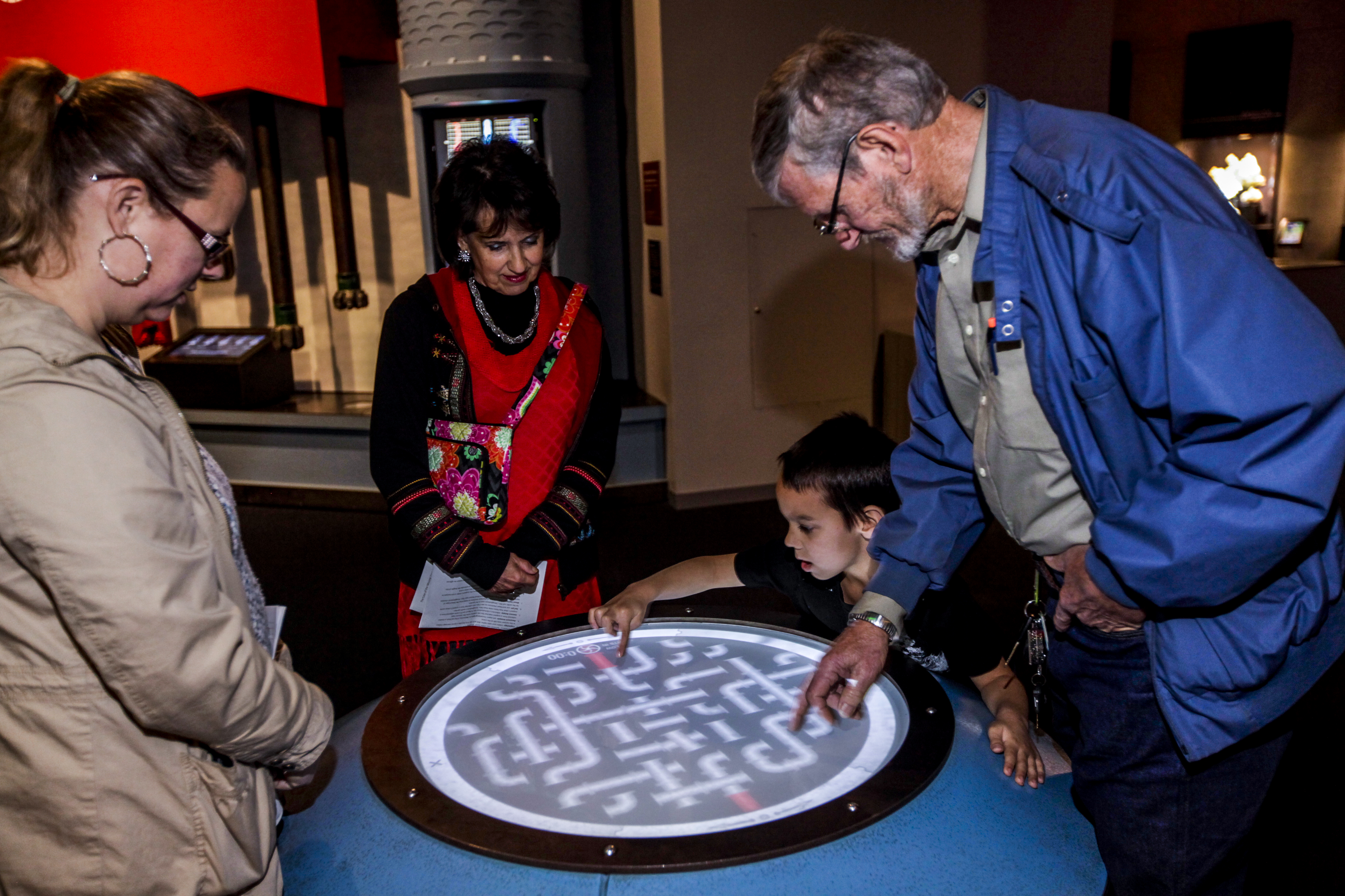 A few adults engage with a museum display.