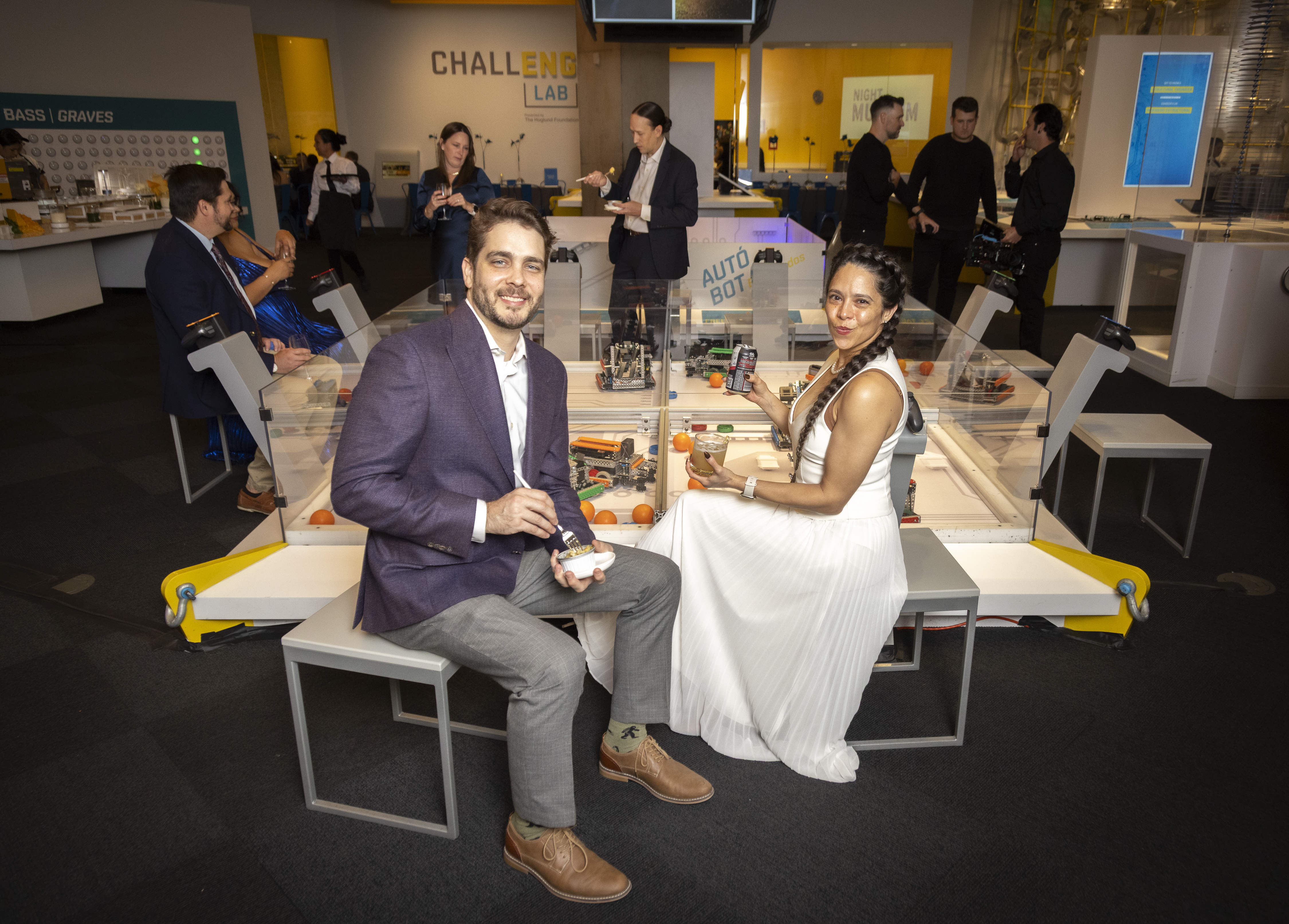 Man and woman sitting at table, smiling and holding drinks
