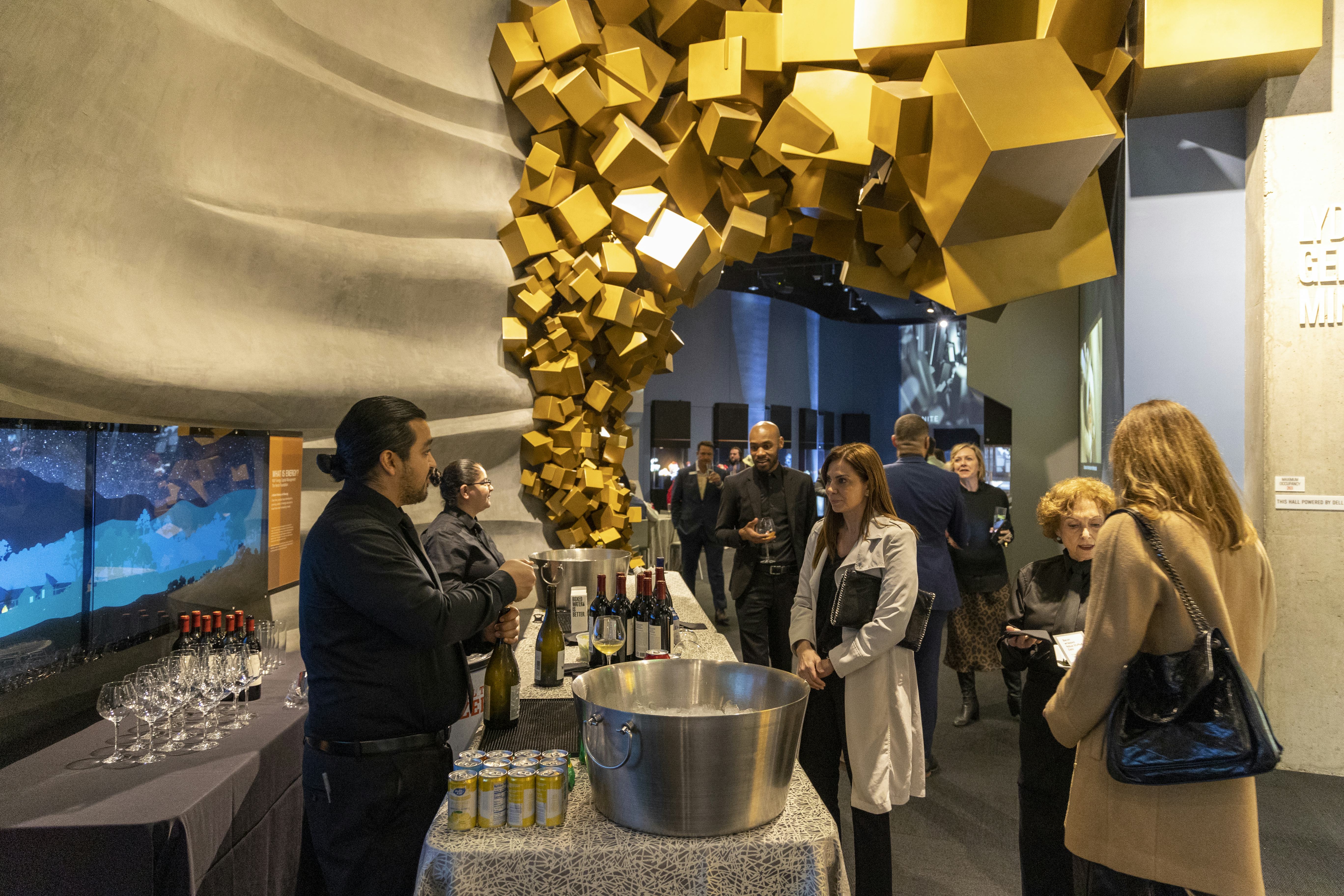 Group of adults in front of table with drinks set up in Museum