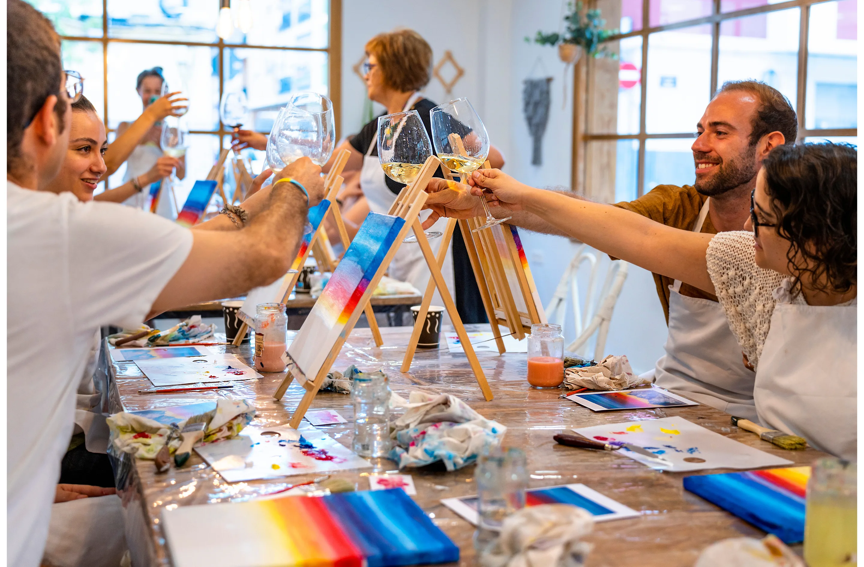 Adults painting and toasting wine glasses
