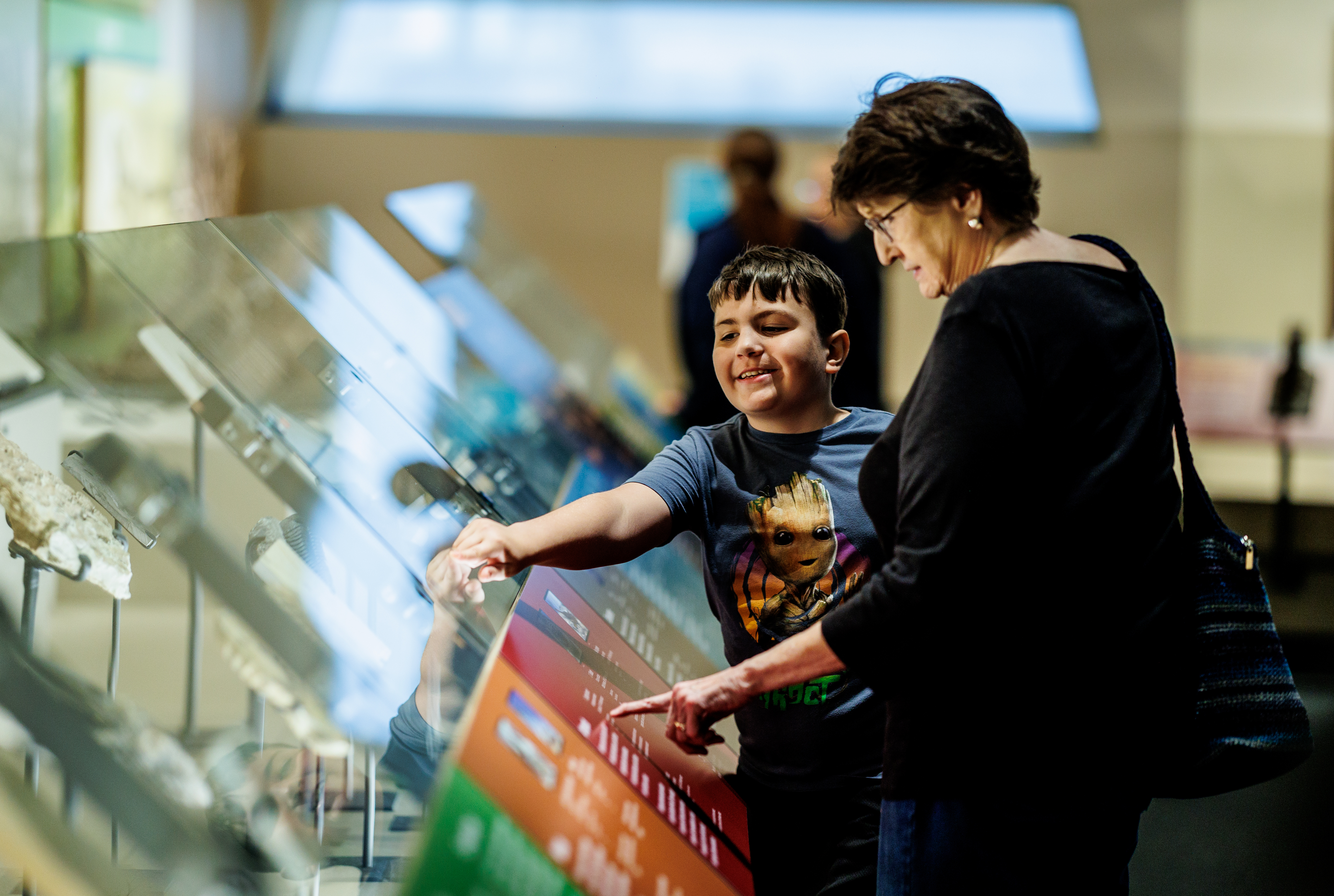 Boy and woman pointing at exhibit