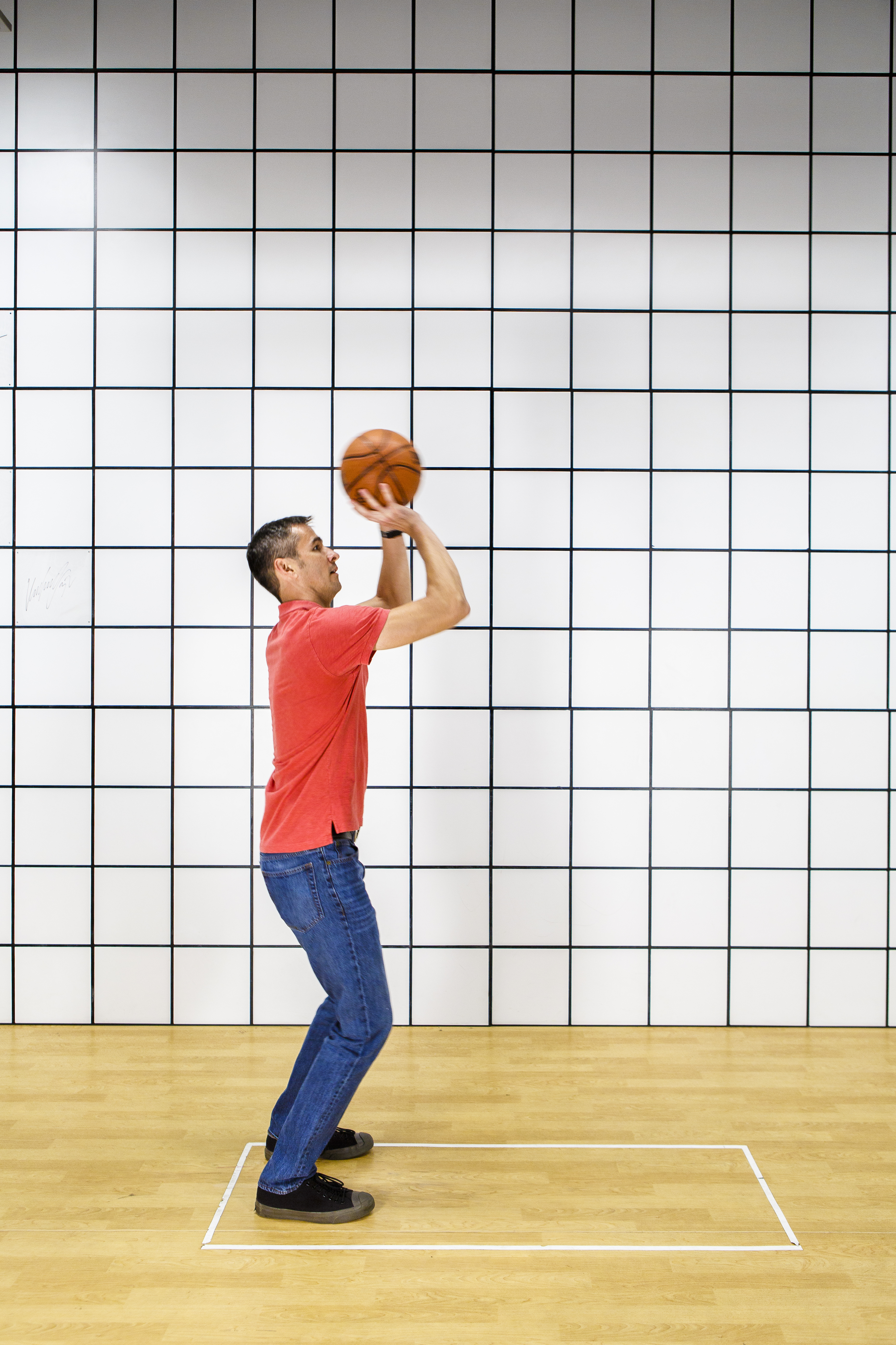 A young man shoots a basketball.